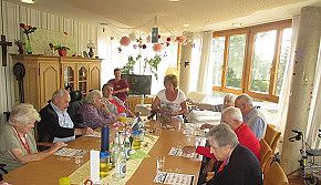 Gemeinsames Spielen - Das Bild zeigt Bewohner*innen des AWO Seniorenheimes Maria Demmel beim gemeinsamen Spielen im Aufenthaltsraum.